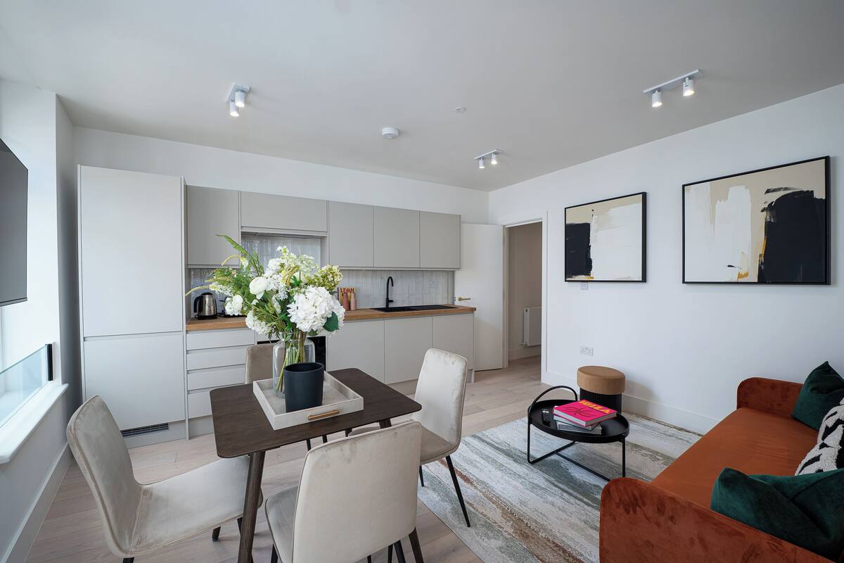 A modern apartment with a dining area, kitchen, and living room.