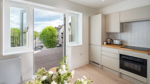 Une cuisine moderne dotée de grandes fenêtres, d’un balcon et offrant une vue sur la ville.