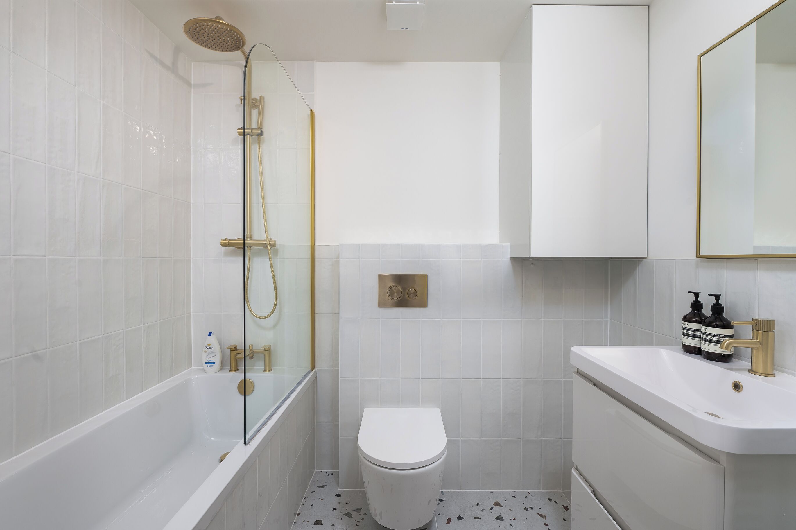A modern bathroom with a bathtub, toilet, and sink.