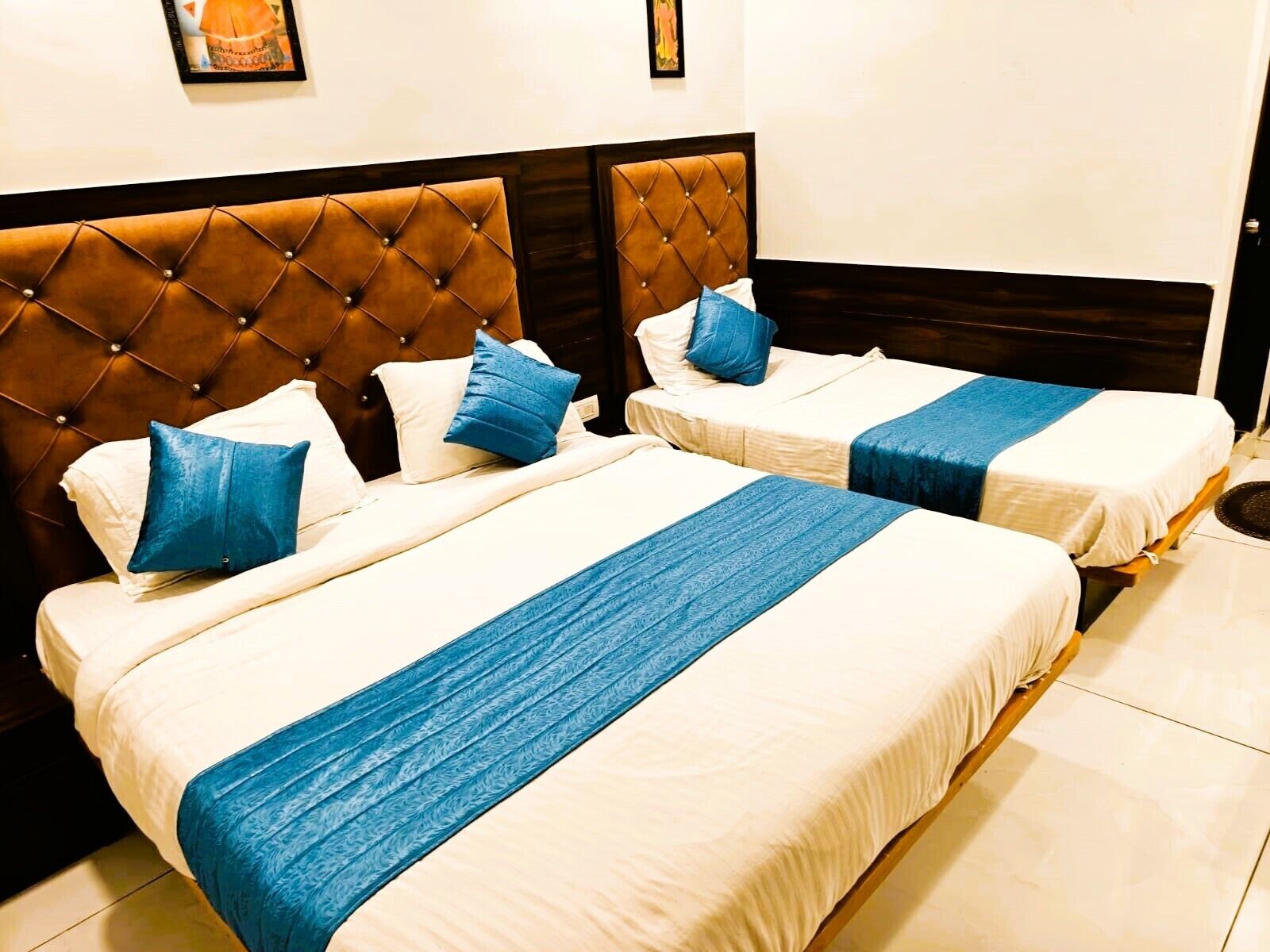 Habitación de hotel con dos camas, cada una con cabecero y almohadas.