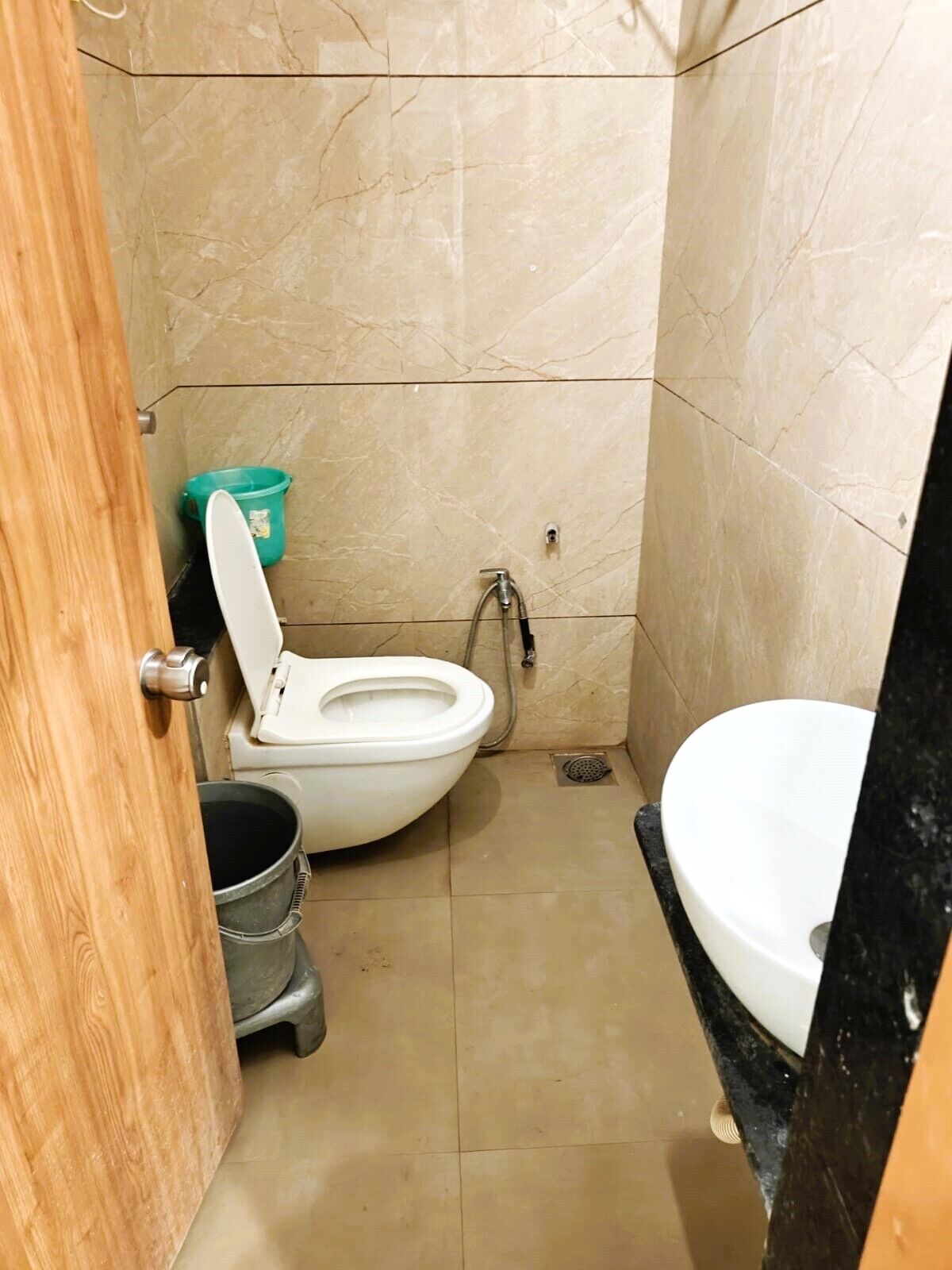 A small bathroom with a toilet, a sink, and a shower.