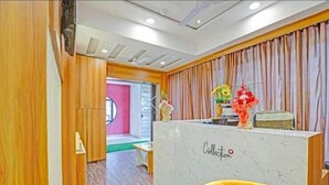 A reception area with a marble counter, wooden paneling, and a curtain backdrop.