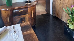 Un comedor de madera con una mesa, sillas y una planta en maceta.