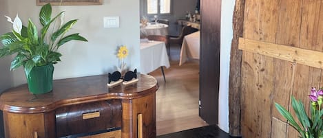 A wooden dining area with a table, chairs, and a potted plant.