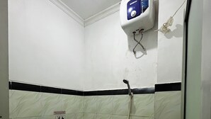 A small bathroom with a toilet, sink, and a hand dryer. - Ez Door (Yogyakarta)
