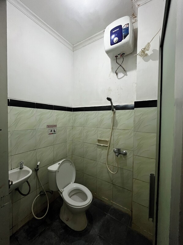 Ein kleines Badezimmer mit Toilette, Waschbecken und einem Händetrockner.