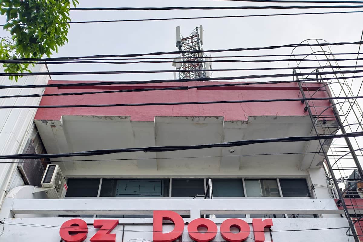 A building with a sign reading "ez Door" and multiple air conditioning units installed on the exterior.