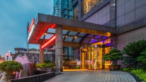 A modern hotel entrance with a glass facade, a covered entrance area, and a water feature. - Chongqing jiayu emperor hotel  (Chongqing)