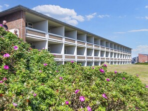 A multi-story building with a brick facade and white balconies.