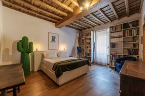 A bedroom with a bed, a green cactus sculpture, a bookshelf, and a wooden ceiling. - A Unique Penthouse with Spectacular Terraces in the Beating Heart of Rome (Roma)