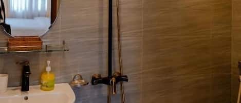 Een badkamer met een modern design, met een wastafel, spiegel en douche.