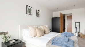 A modern bedroom with a bed, bedside table, and a wardrobe. - Spacious 1BR Apartment in Central Leeds (Leeds)