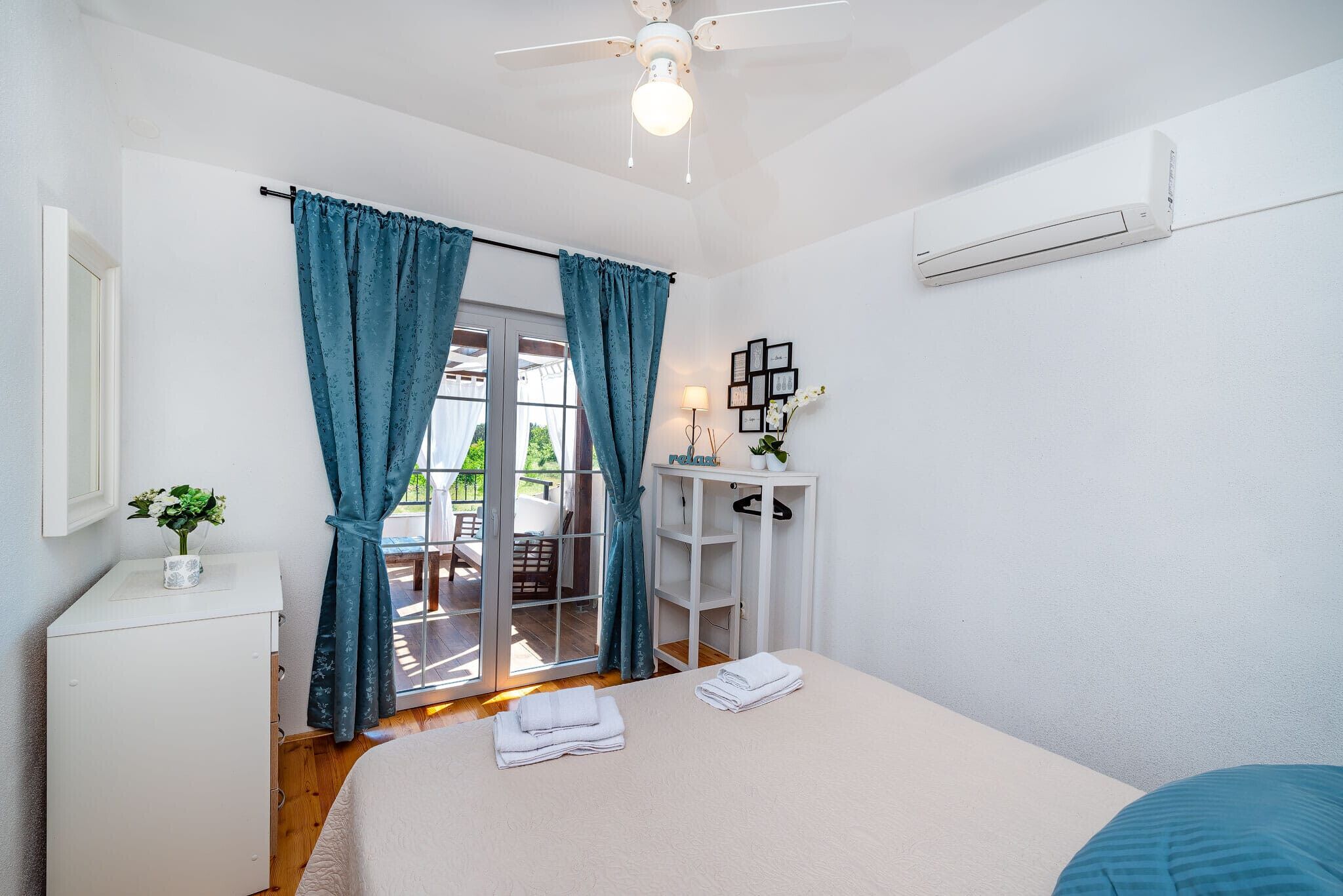 Un dormitorio con cama, escritorio, silla y ventilador de techo.