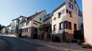 Una hilera de edificios europeos tradicionales con una mezcla de estilos arquitectónicos, incluyendo un edificio con un cartel que dice "Landgasthof Krone".