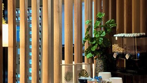 Een moderne keuken met houten latten, een potplant en een koffiehoek.