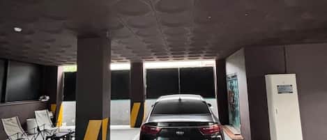 Un garaje de estacionamiento con un coche negro aparcado en un lugar.