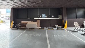 A parking garage with a modern design, featuring a ceiling with circular patterns and a concrete floor. - Casa Incanto Hotel in Gumi (Gumi)