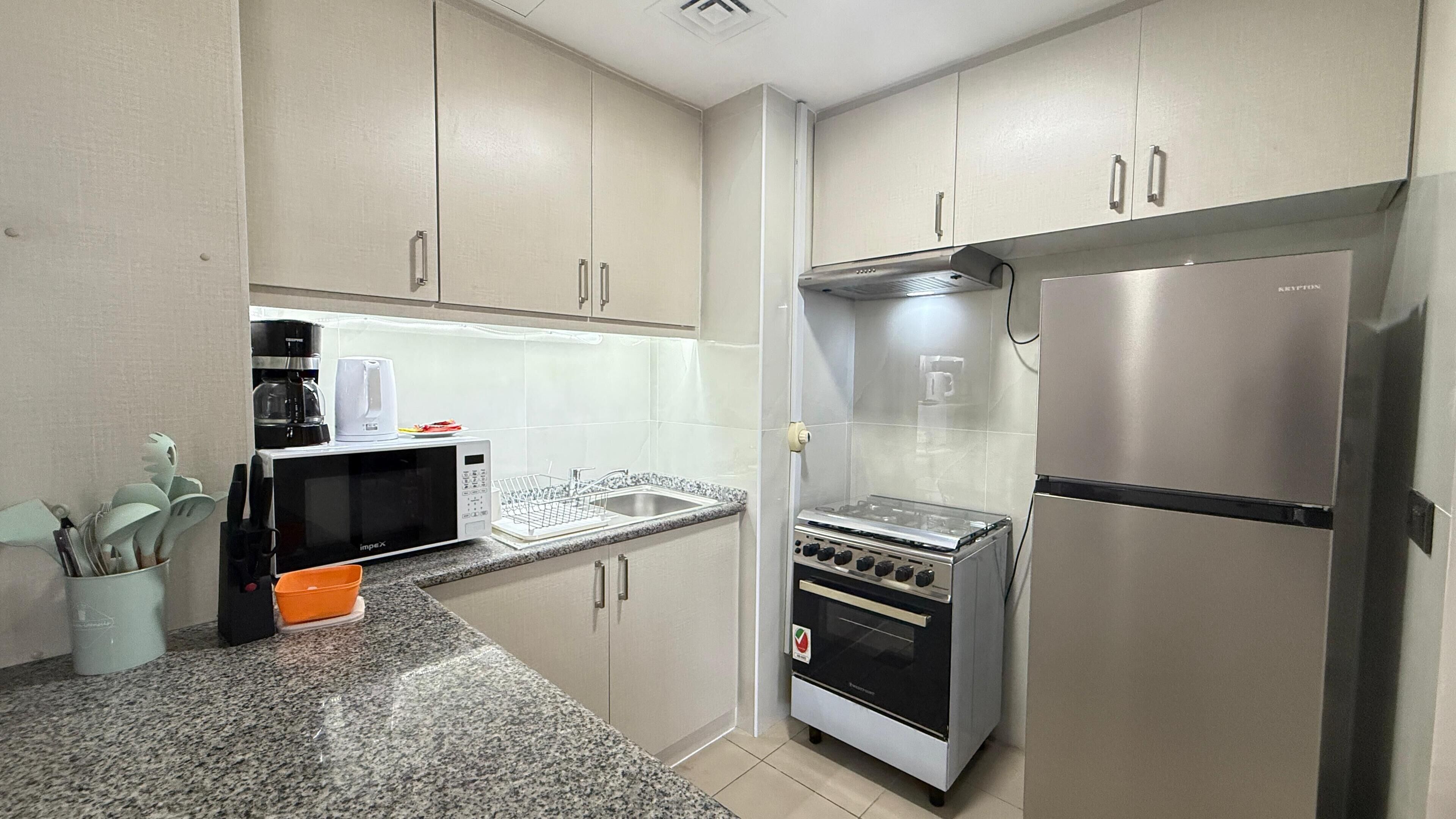 A compact kitchen with a microwave, toaster, and refrigerator.