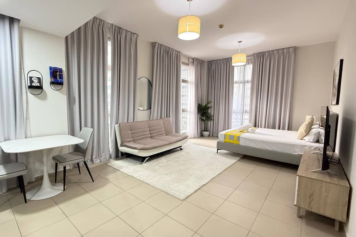 Une chambre d’hôtel moderne équipée d’un lit, d’un canapé, d’un bureau et d’une chaise.