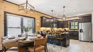 A modern kitchen with dark cabinets, stainless steel appliances, and a central island. - Villa De Luxe by Beyond Expectations: Cabin w/ Indoor Pool, Hot Tub & Game Room (Pigeon Forge)