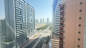 A high-rise building with a modern architectural design, featuring multiple balconies and a clear view of the surrounding urban landscape.