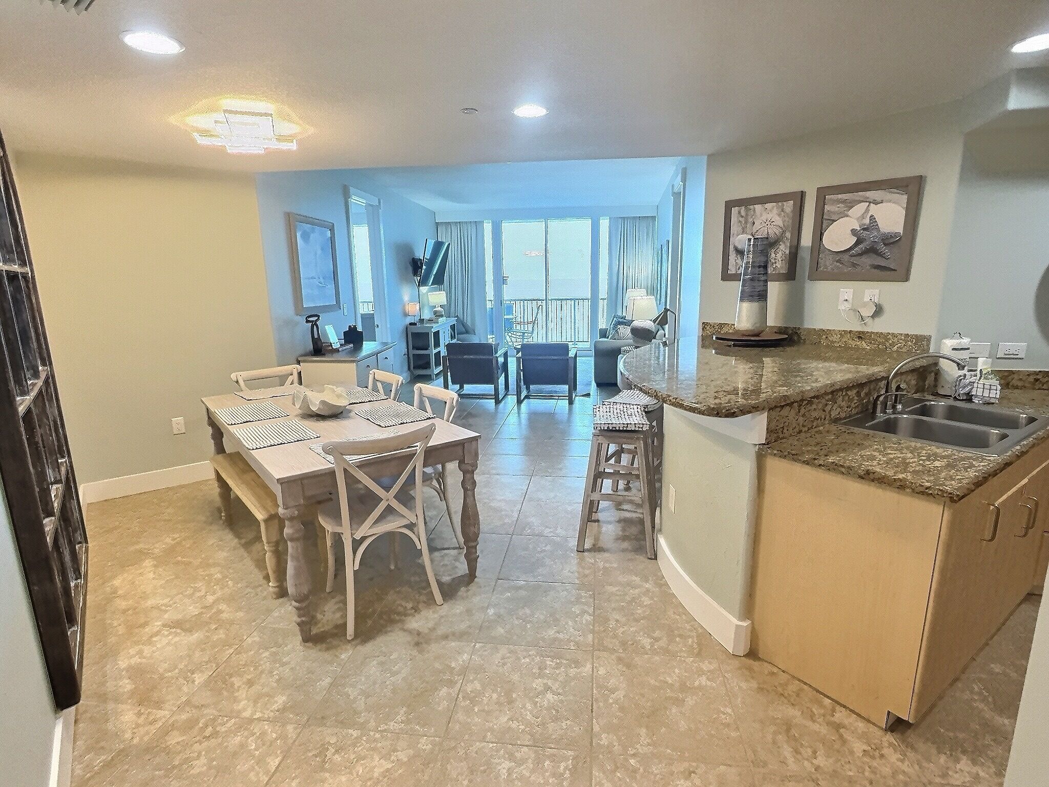 Una cocina amplia con encimera de granito, un lavabo y un comedor con mesa y sillas.