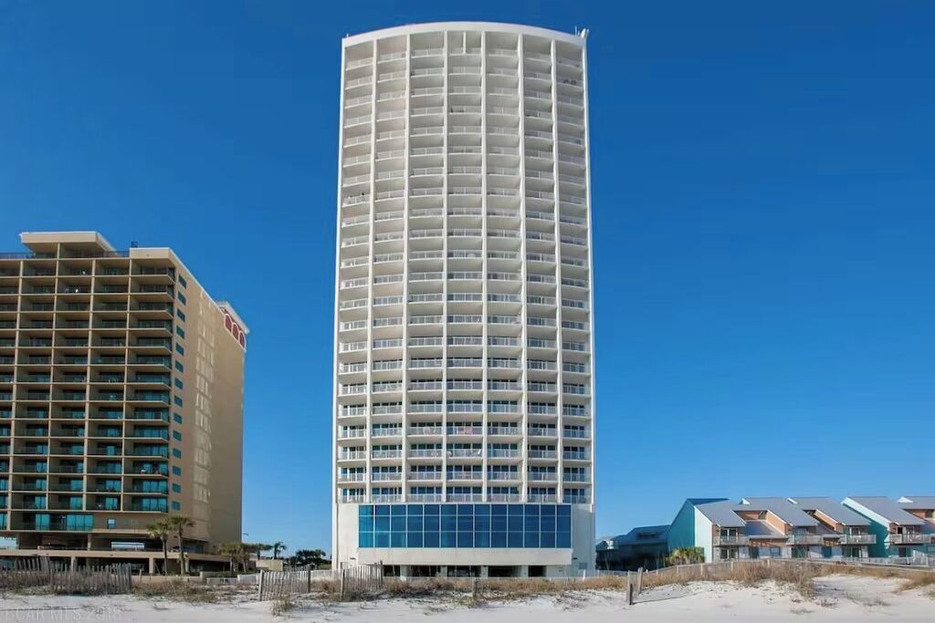 Un hotel alto y cilíndrico con múltiples balcones y un diseño moderno.