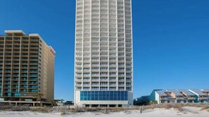 Een hoog, cilindervormig hotel met meerdere balkons en een modern design.