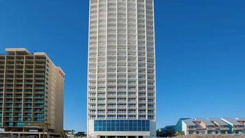 Un hotel alto y cilíndrico con múltiples balcones y un diseño moderno.