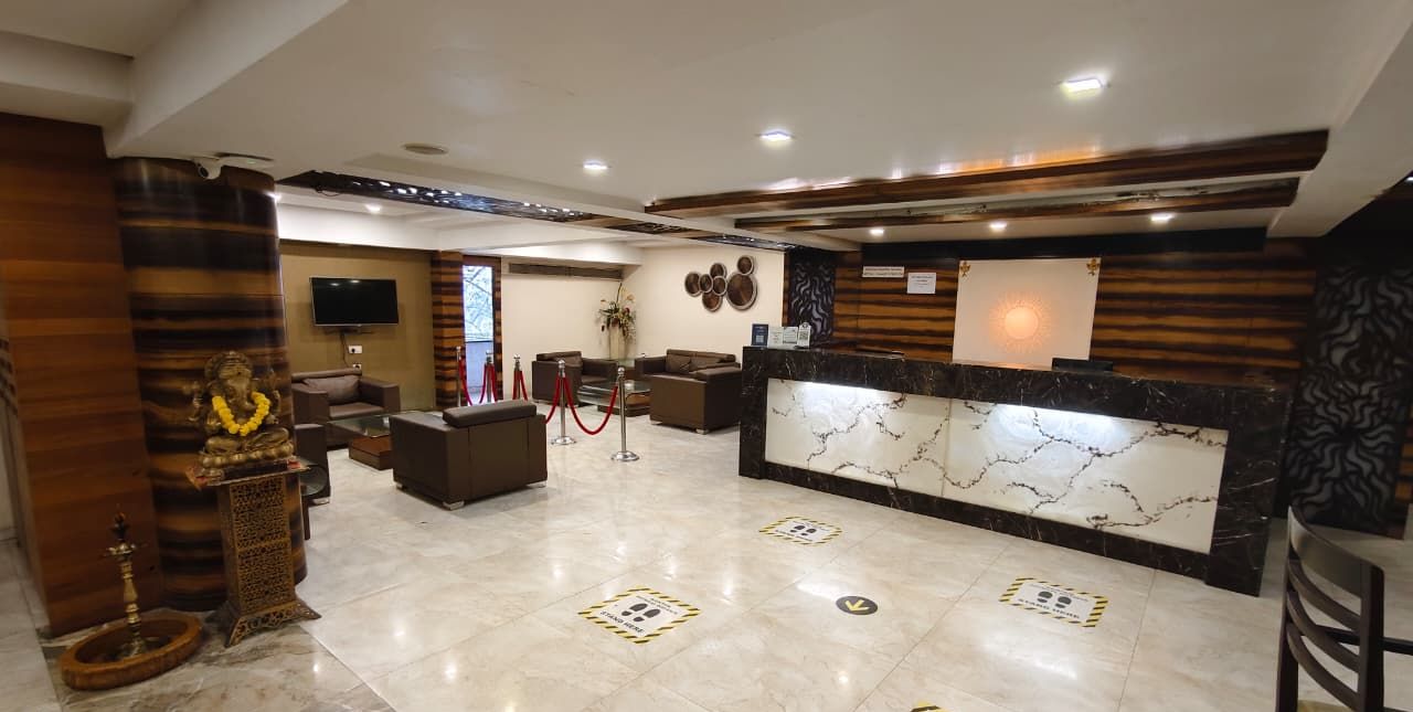 Un moderno vestíbulo de hotel con una recepción, zona de estar y una estatua.