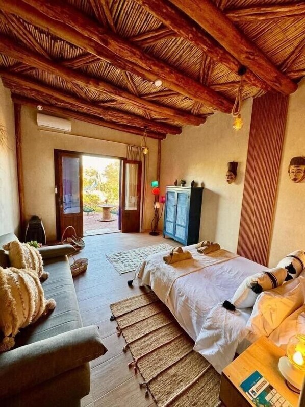 Una habitación con cama, sofá, televisor y armario.