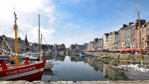 A harbor with boats docked, stone piers, and historic buildings along the water. - Maison agréable près Etretat (Beaurepaire)