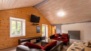 A wooden interior with a TV, sofa, and fireplace. - Holiday Home 'À Isturits Avec Piscine' with Shared Pool, Private Terrace and Wi-Fi (Isturits)