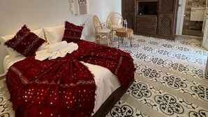 A room with a large bed, a TV, and a wardrobe. - Riad El Ghali Prestige (Marrakech)