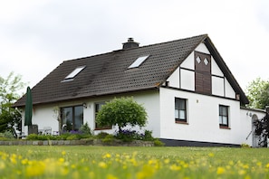 A house with a sloped roof, a chimney, and a window with a view of the sky. - Holiday Home 'Ferienhaus Schober' with Private Terrace, Garden and Wi-Fi (Cuxhaven)