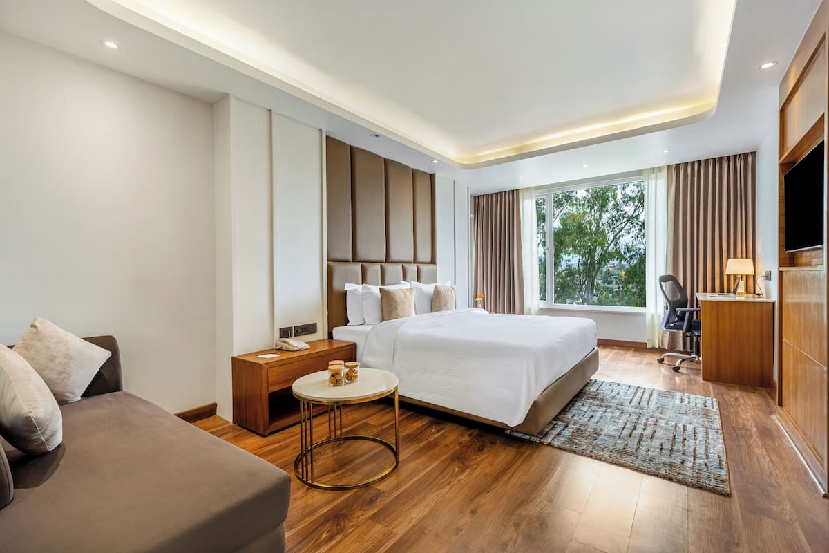 Une chambre d’hôtel moderne équipée d’un grand lit, d’un canapé, d’un bureau et d’une télévision.