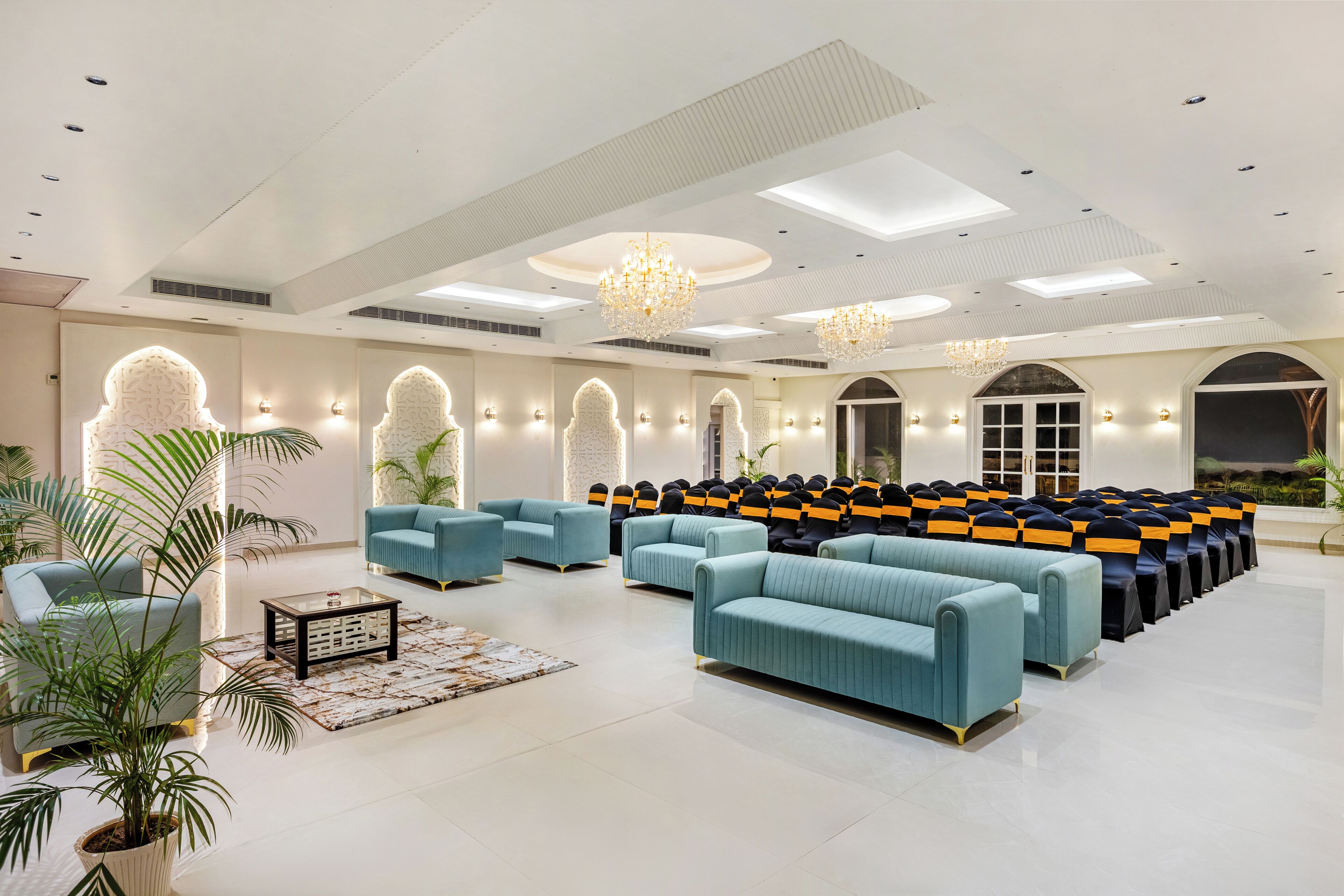 A spacious lobby with modern seating, a chandelier, and a large window.