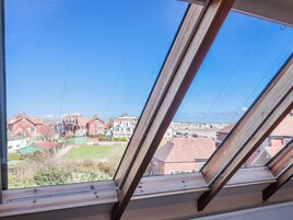 Vista a través de un tragaluz de una zona residencial con casas y un espacio verde.