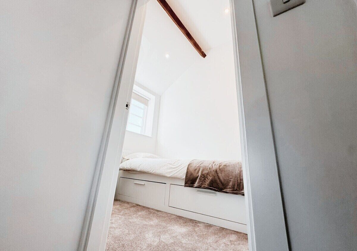 Quarto com uma cama, janela e porta.