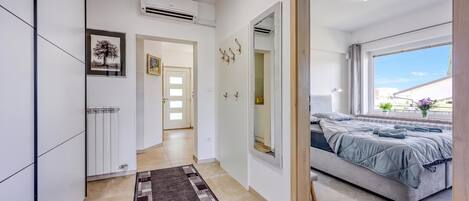 Un dormitorio moderno con cama, un espejo grande y vistas al exterior.