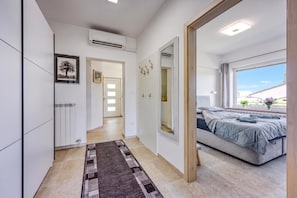 Un dormitorio moderno con cama, un espejo grande y vistas al exterior.