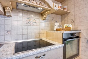 A kitchen with a built-in stove, oven, and a wooden countertop.