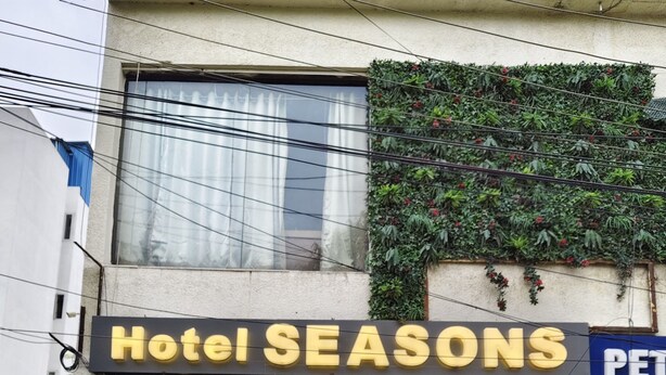 L’entrée d’un hôtel, avec une enseigne indiquant « Hôtel Seasons ».