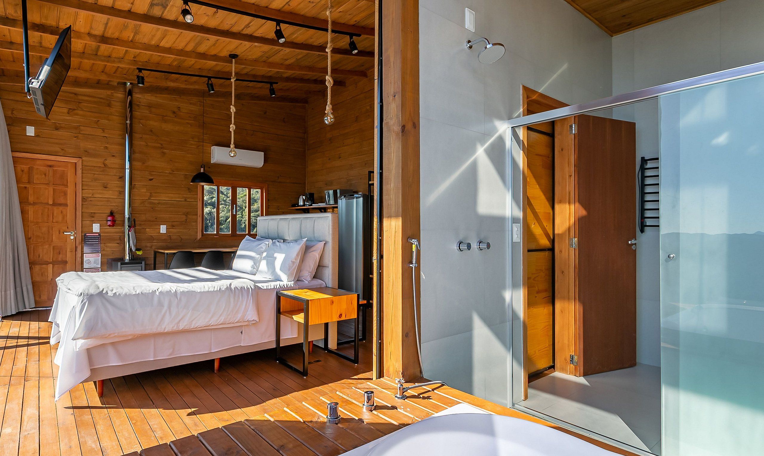 Une chambre à coucher moderne avec un lit, une table de chevet et une grande fenêtre.