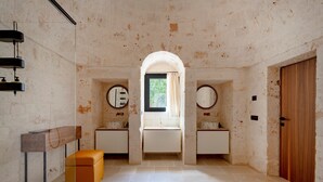 A bathroom with a wooden bench, a mirror, and a sink. - Villa 'Dimora Dormio' with Private Pool, Wi-Fi, and Air Conditioning (monopoli)