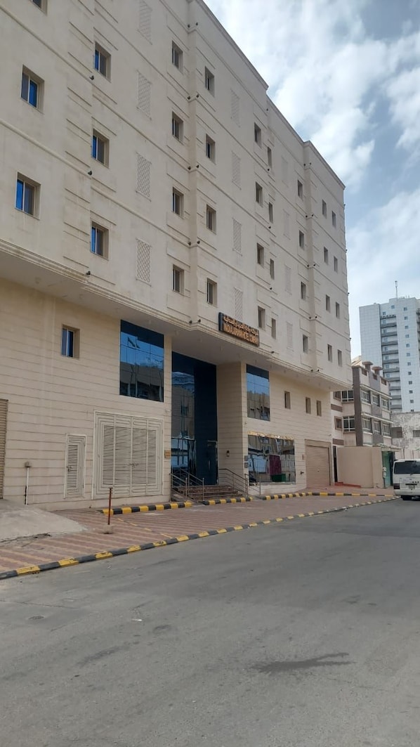 Um edifício de vários andares com entrada central, janelas amplas e fachada plana.