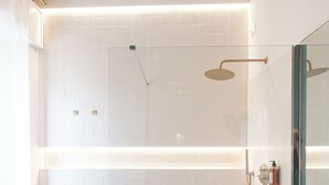 Une salle de bain moderne avec une douche à parois de verre, une baignoire blanche et un meuble-lavabo en bois.