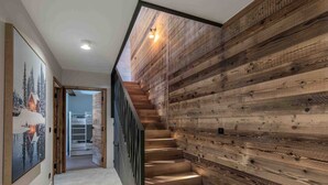 A modern staircase with wooden paneling and a view into a bedroom. - Modern duplex near slopes with parking (Courchevel 1550)