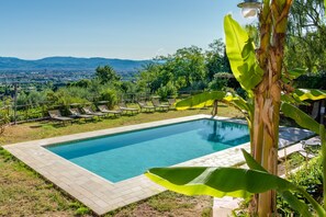 A rectangular swimming pool with a tiled border, surrounded by lounge chairs and a view of distant mountains. - Studio 'Il Poderaccio Tramontana' with Shared Pool, Wi-Fi and Air Conditioning (Scandicci)