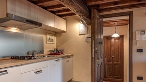 A kitchen with white cabinets, a stainless steel range hood, and a wooden ceiling. - Studio 'Il Poderaccio Tramontana' with Shared Pool, Wi-Fi and Air Conditioning (Scandicci)